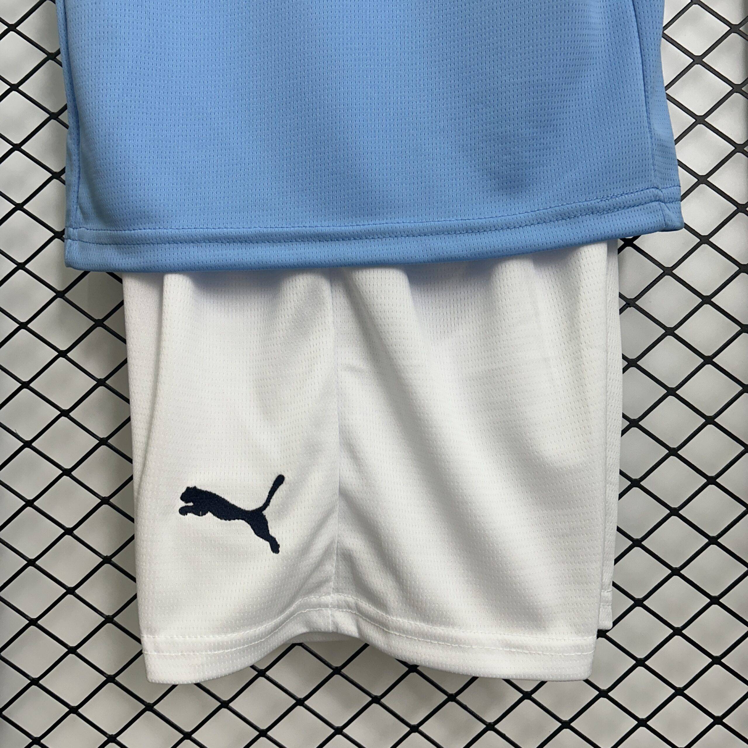 Maglia bambini Manchester City 25/26, taglie 16-28, design blu, ideale per allenamento e partite.