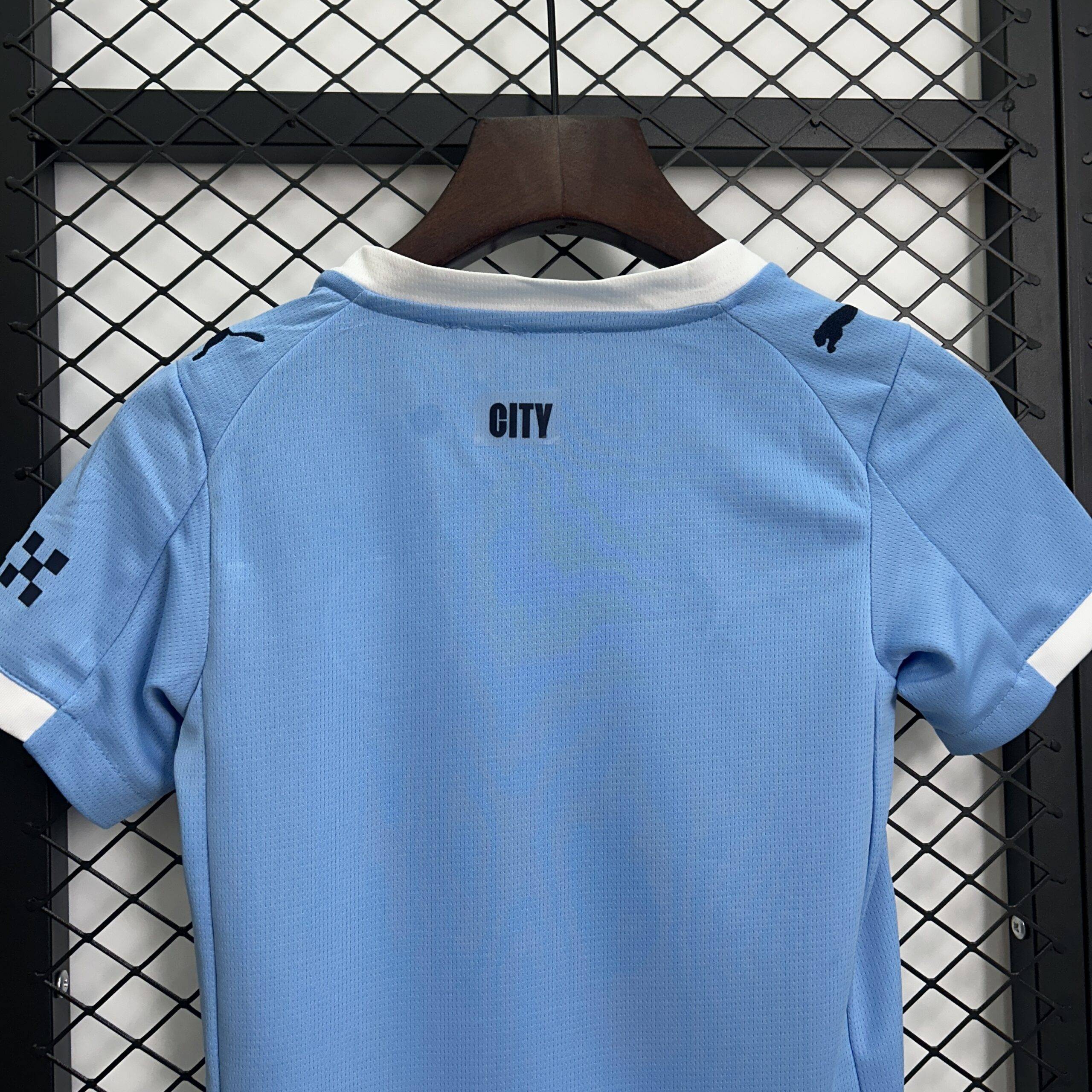 Maglia bambini Manchester City 25/26, taglie 16-28, design blu, ideale per allenamento e partite.
